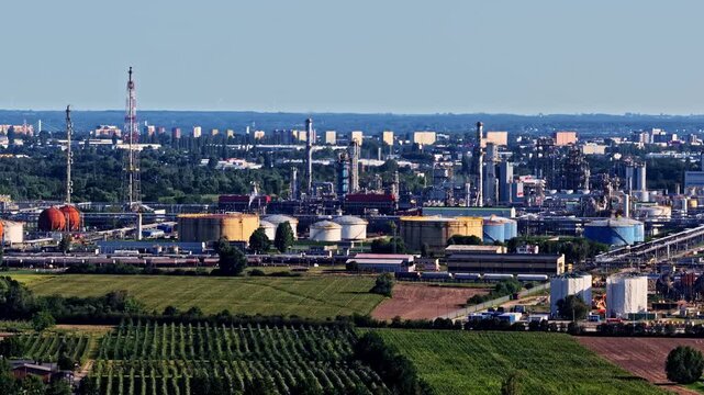 Aerial view of the Orlen Plock Production Plant featuring industrial storage tanks, tall refinery towers, and surrounding green fields in Plock, Mazowieckie, Poland.