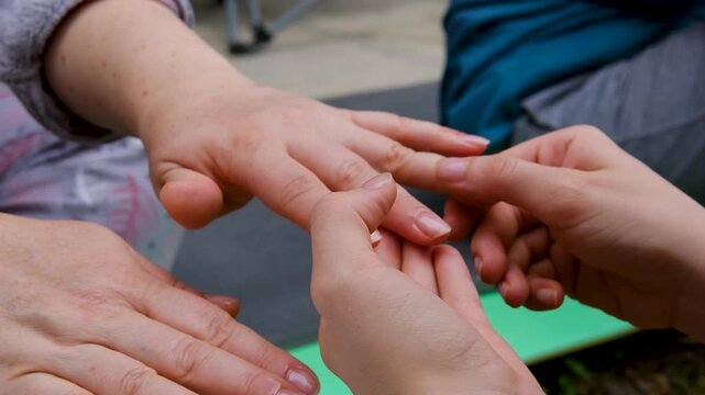 Step by step homemade manicure outdoors includes soaking hands with lemon and herbs, removing old polish, trimming nails, applying polish, oil, massage and hand cream. Close up.