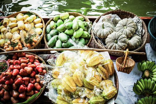 floating market - top view of boat full of fresh fruits on sale