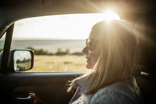 beautiful woman traveler in a car at sunset