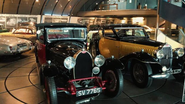 Showcase of rare vintage classic cars displayed in a museum hall featuring retro convertible sports vehicles, antique automobiles, and beautifully restored historical motor cars on luxury exhibition 