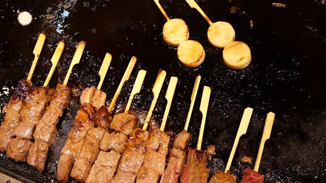Japanese Teppanyaki Kushiyaki of grilling meat on griddle