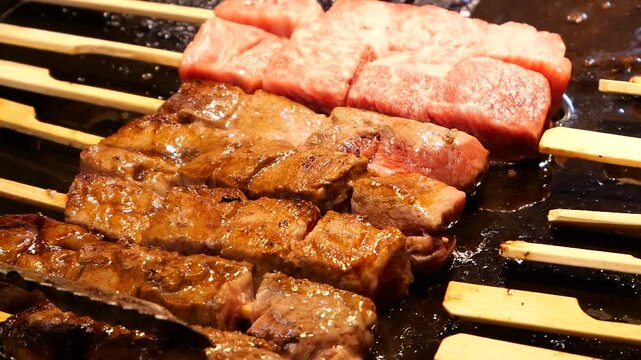 Japanese Teppanyaki Kushiyaki of grilling meat on griddle