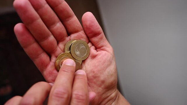 Close up of male hands holding and counting turkish lira coins, illustrating personal finance, national economy, inflation, budgeting, and everyday money management concepts, financial crisis