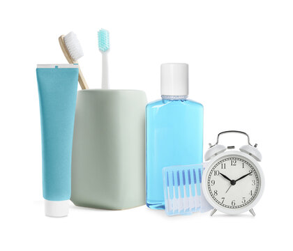 Dental care products and alarm clock isolated on white. Oral hygiene routine