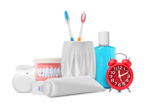 Dental care products, alarm clock and model of jaw isolated on white. Oral hygiene routine