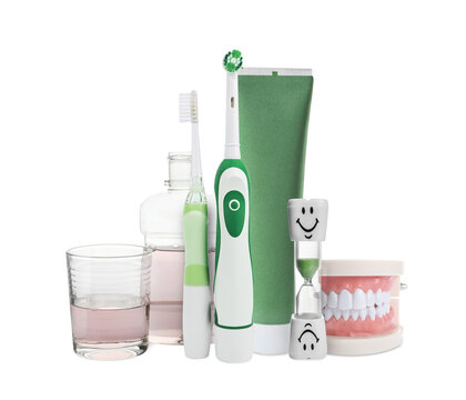 Dental care. Toothbrushes, toothpaste, mouthwash, hourglass and model of jaw isolated on white