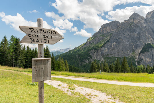 12 July 2026, Col dei Baldi, Alleghe, Italy. Rifugio Col dei Baldi signpost with dramatic Dolomite mountain landscape