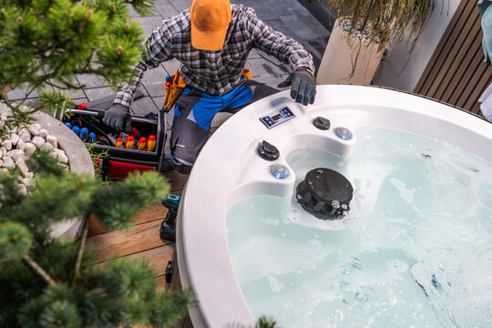 Technician inspecting an outdoor hot tub from above
