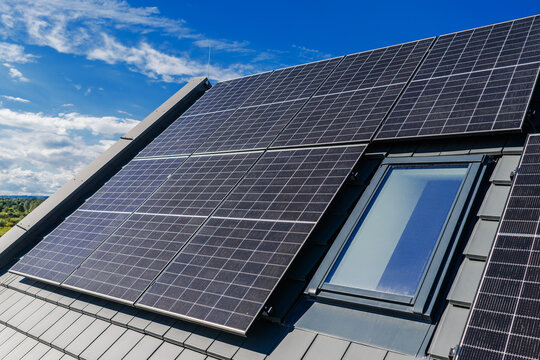 Close view of photovoltaic panels beside a roof window