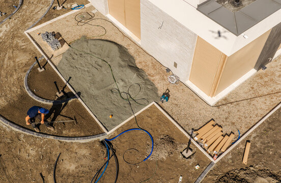 Aerial view of garden path construction beside a modern house