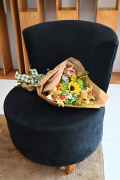 colorful flower bouquet wrapped in kraft paper, vibrant floral arrangement with sunflower, peach lilies, white alstroemeria and yellow orchids, gift bouquet close up