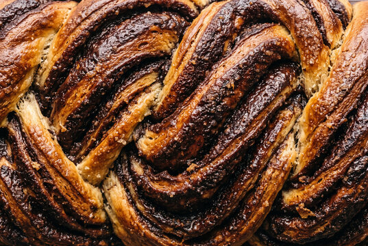 Close-up texture of baked chocolate babka bread with braided dough layers and shiny crust