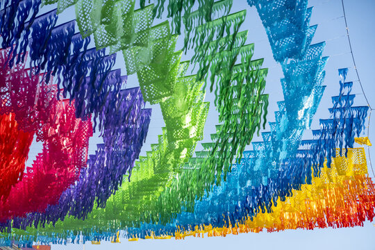 View of colorful papel picado banners hanging above a street in Oaxaca, Oaxaca, Mexico.