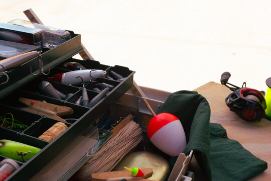 Fishing equipment and accessories are packed into a tackle box, showcasing a collection of lures and bobbers ready for an outdoor fishing adventure