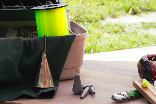 Fishing equipment displayed on a rustic wooden surface, highlighting essential tools such as lines and a reel ready for a day of outdoor fishing.