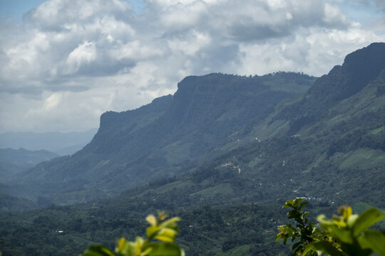 View of the lush green mountain range under a cloudy sky in Agua Azul, Chiapas, Mexico.
