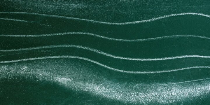 White chalk waves on a dark green textured surface