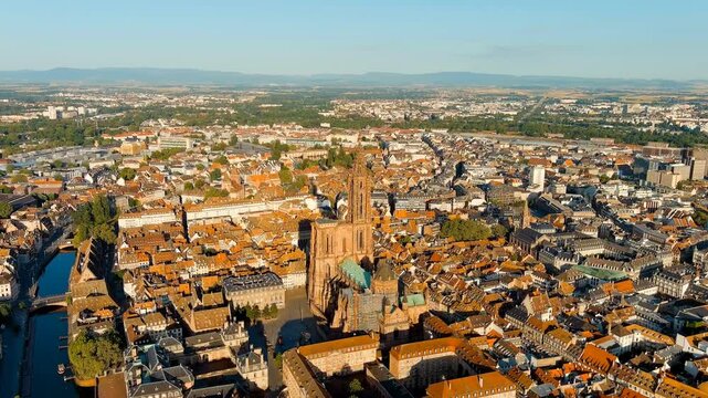 Strasbourg, France. Strasbourg Cathedral, a single Gothic spire rising 142 meters above terracotta rooftops, Drone footage on a clear summer morning. Drone footage, Point of interest