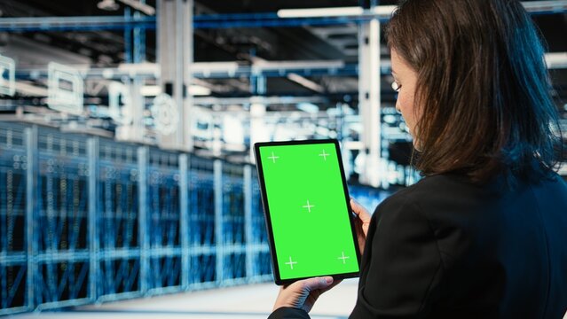 Data center admin uses a green screen tablet to optimize server load balancing and adjust system parameters for better efficiency in a server farm.