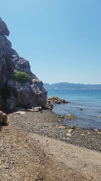 Beautiful rocky beach with transparent sea on Turkish Riviera in Marmaris, Turkey. Handheld, Vertical video