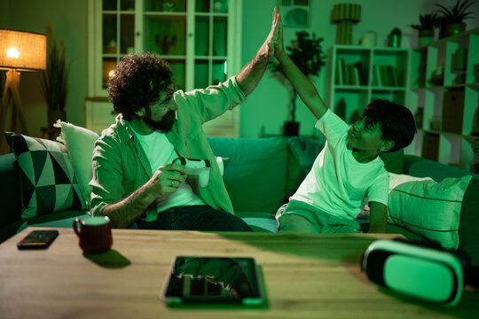 Father and son high-fiving playing video games