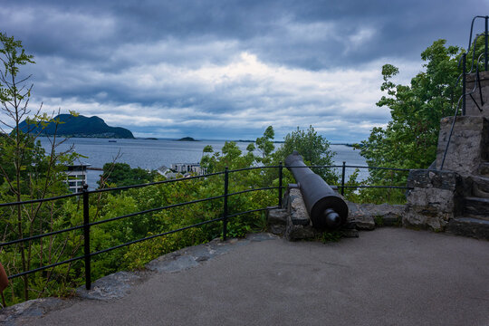 Cannon overlooking fjord with islands and mountains, Norway coastal viewpoint