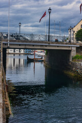 Gondola boat under bridge with red flag, harbor waterway Norway © Earthly Shots