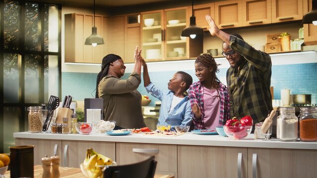 Parents and kids unite hands during pizza day activity