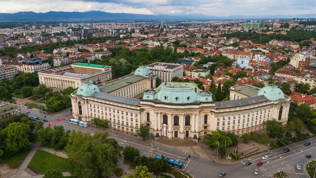 Sofia, Bulgaria - 02 June 2026: Aerial view of Sofia University with its iconic green domes, surrounded by lush trees and urban streets in the city center.