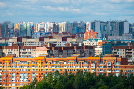 Modern city skyline panorama with residential apartment buildings under blue sky.

