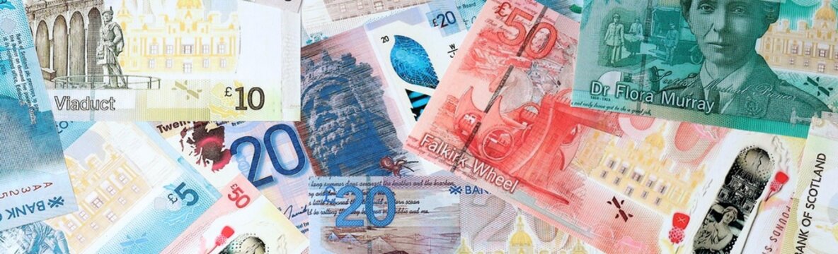 Scottish pound money bills in pile on table. Scotland GBP currency cash close up