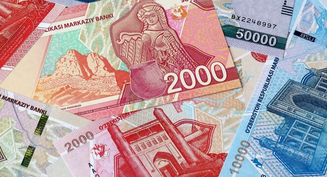 Uzbekistani som money bills in pile on table. Uzbekistan UZS currency cash close up