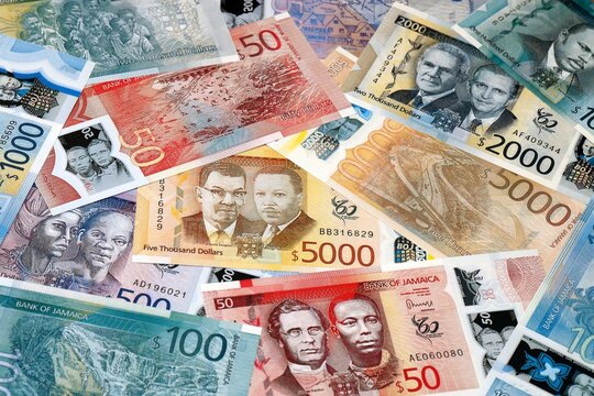 Jamaican dollar money bills in pile on table. Jamaica JMD currency cash close up