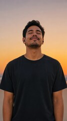 Fototapeta premium Young Latino Man Enjoying Music with Wireless Earbuds Outdoors at Sunset