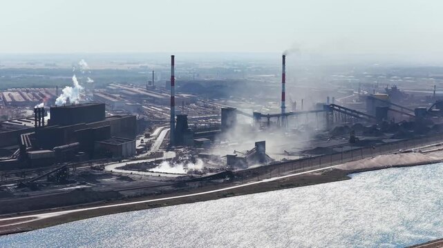 Aerial drone view of a heavy metallurgical plant producing steel. Industrial facility with manufacturing buildings and infrastructure.