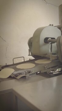 Industrial tortilla machine producing tortillas on conveyor belt