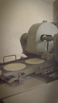 Tortilla machine moving round tortillas along conveyor belt