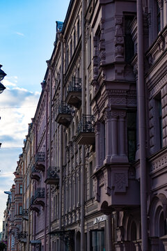 Classic historic building stone facade with art nouveau ornaments and windows pattern close up.
