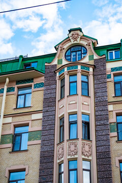 Classic historic building stone facade with art nouveau ornaments and windows pattern close up.
