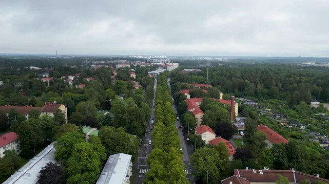 Beautiful aerial drone video of Kumpula Allotment Gardens in Helsinki, Finland, surrounded by lush green vegetation, garden plots, small cottages, and peaceful summer scenery.