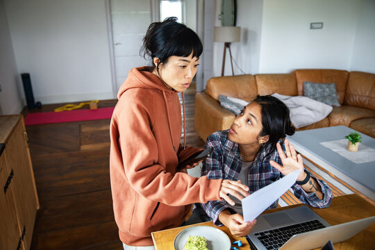 Two women discussing household finances at home
