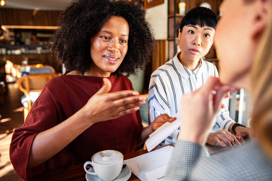 Businesswomen discussing project during meeting at cafe