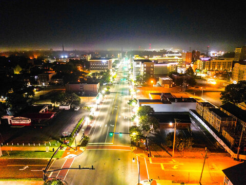 Aerial view of the illuminated streets and buildings of downtown Wilmington at night, featuring glowing streetlights and urban architecture in Wilmington, North Carolina, United States.