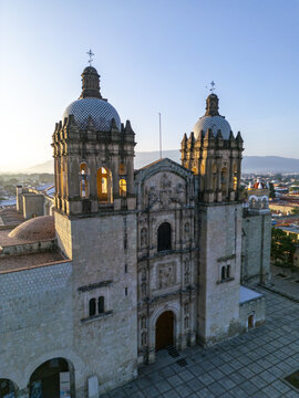 Aerial view of Templo de Santo Domingo de Guzman with its ornate baroque facade and tiled domes illuminated by the soft morning light in Oaxaca, Oaxaca, Mexico.