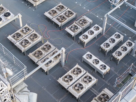 Aerial view of an AI data center cooling system featuring rows of industrial fans on a metal rooftop in Krakow, Lesser Poland Voivode, Poland.