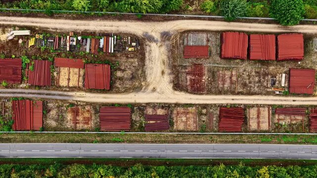 Aerial flyover of industrial storage yard divided by dirt road and surrounded by trees at Hambach mine