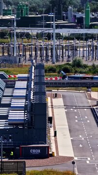 Rows of industrial buildings and power infrastructure at a large construction site