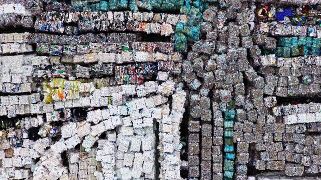 droneshot of hundreds of crushed, compressed cubes of recyclable plastic and paper waste.