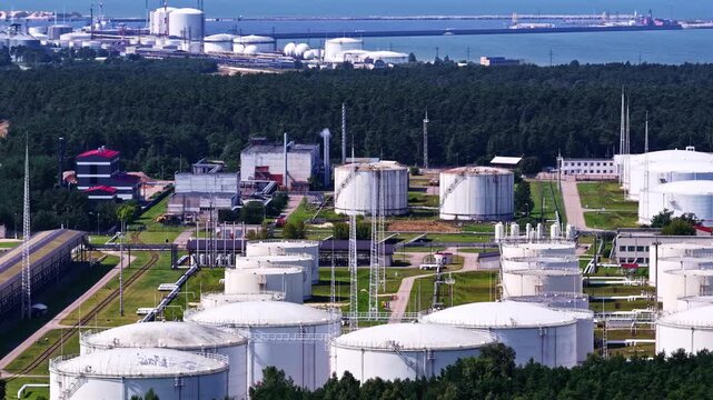 Large oil refinery storage tanks situated close to the coastline.